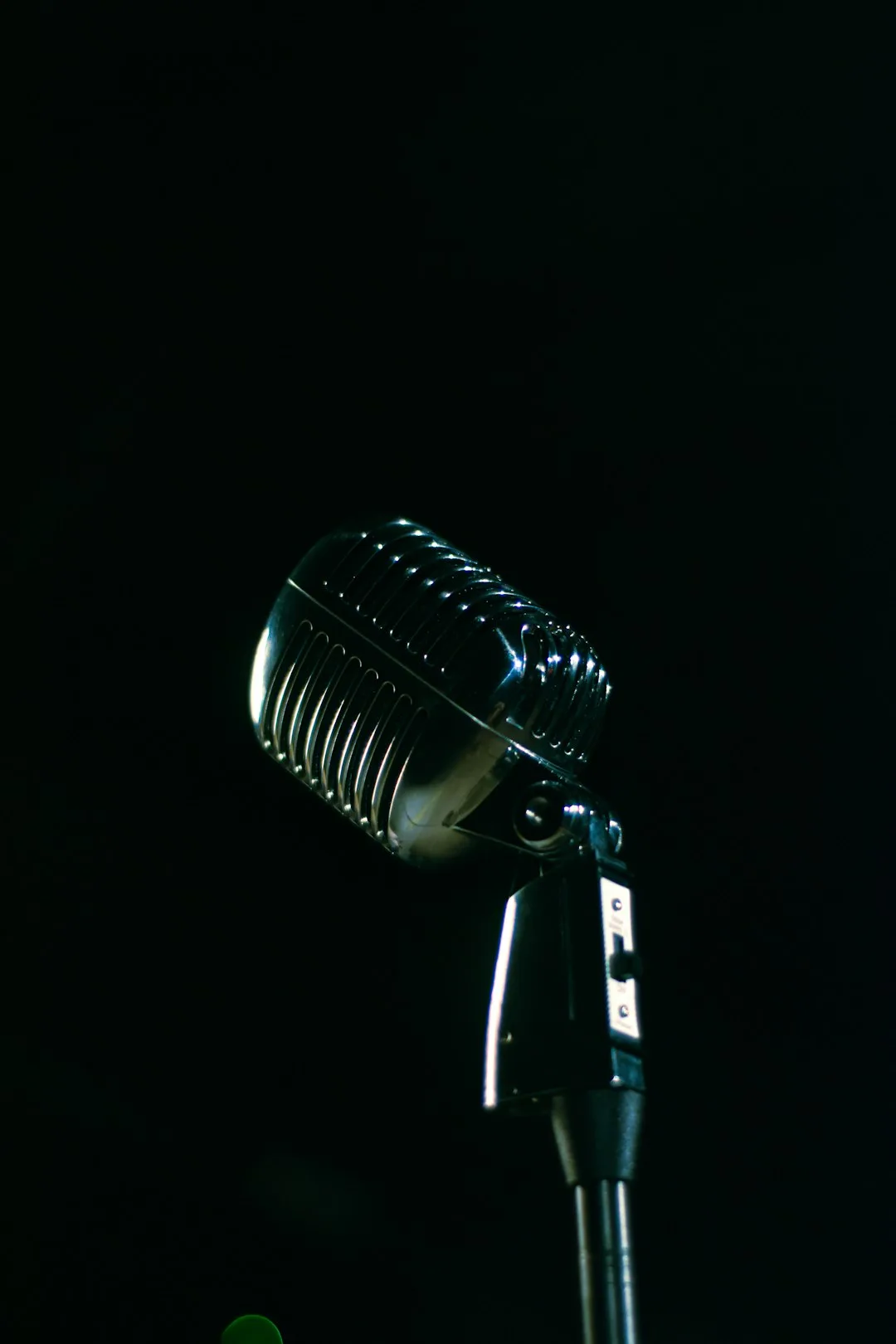 A microphone is shown in the dark with a blurry background